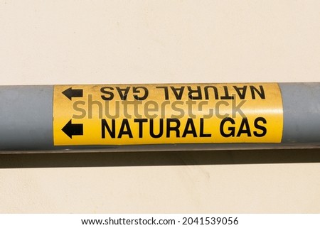 Natural gas marker on pipe with an arrow to indicate flow.