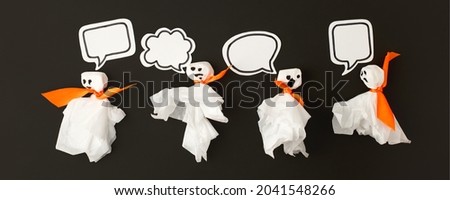 Halloween party concept - ghosts from paper napkin with speaking bubbles for text on black background, creative invitation for night party, promotion flyer, banner for site, message, chating