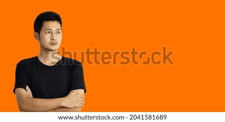 man wearing black t-shirt isolated with orange background. People on orange background 