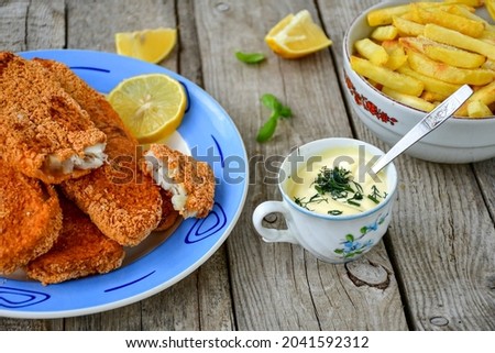  Fish and chips.Close up of crispy breaded  deep fried alaska pollock  fillets  with breadcrumbs served with remoulade sauce french fries  and  lemons