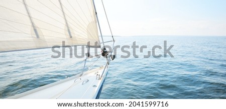 White yacht sailing on a sunny summer day. Top down view from the deck to the bow, mast and sails. Waves and water splashes. Clear blue sky. Gulf of Finland Royalty-Free Stock Photo #2041599716