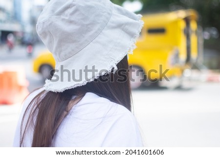 Portrait of a woman turning around in a white hat