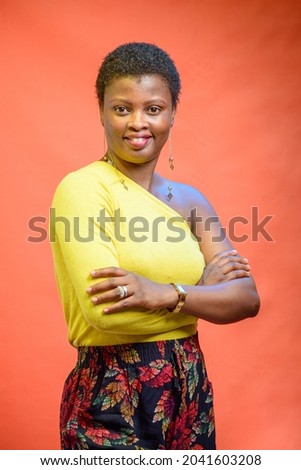 Portrait picture of an African Nigerian lady or woman wearing a yellow top with a low cut hairstyle on her head