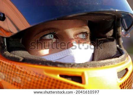 Symbol image: Female race car driver wears helmet and balaclava (Model released) Royalty-Free Stock Photo #2041610597