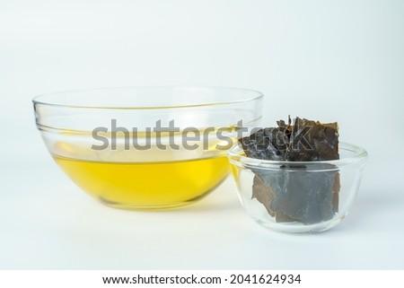 Dashi or Japanese soup stock in the glass bowl with dried kombu seaweed isolated on white background.
