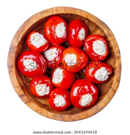 Small red cherry peppers stuffed with soft cheese in wooden bowl isolated on white background. Top view. Royalty-Free Stock Photo #2041694618