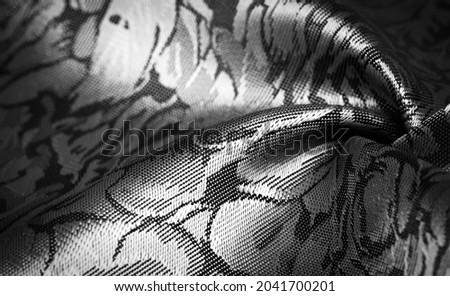 black silk fabric with a floral pattern, unique shine; embossed pattern, composite textile. relief pattern