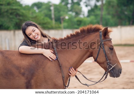 Happy girl embracing brown horse
