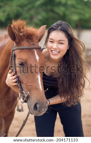 Happy young girl hugging a pony