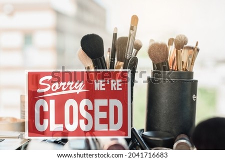 Closure sign in front of beauty salon treatment products, makeup tools and equipment due to quarantine