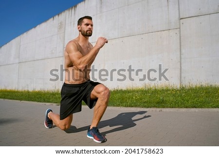 Lunges exercise. Athletic man doing workout outdoors Royalty-Free Stock Photo #2041758623