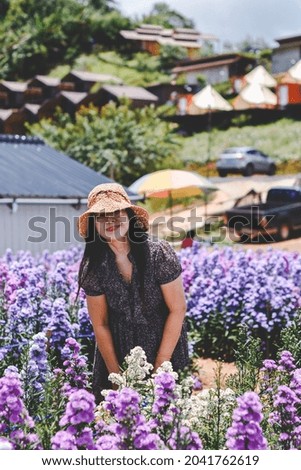 Elderly woman taking pictures with purple flowers