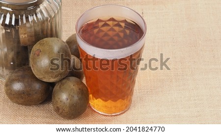 Monk fruit or Luo Han Guo. Dried fruits for healthy sweetener drink. Natural herbal remedy and glass bottle background. Monk fruit drink for who concern health and sugar substitute. 