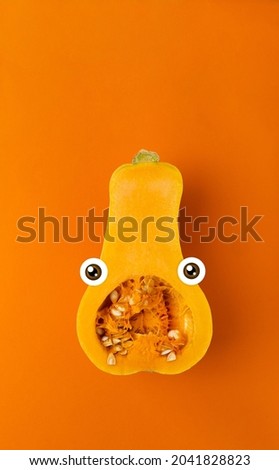 Pumpkin spooky scary vegetable ideal for Halloween party on an orange background with pop eyed view. Vertical thanksgiving banner.
