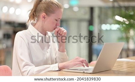 Sick Businesswoman with Laptop Coughing in Office