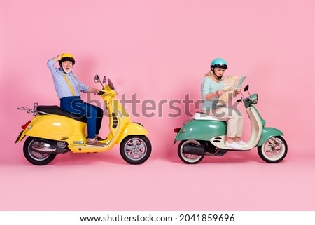Full body profile side photo of aged friend ride scooter lost look map vacation tourism isolated over pink color background