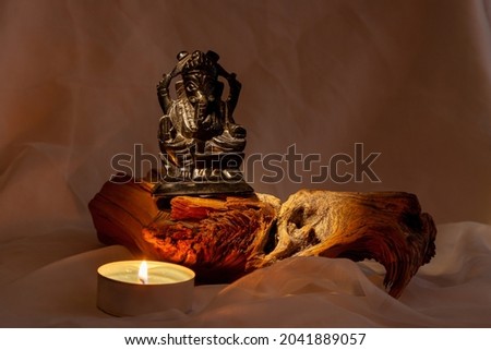 God with an elephant's head on a background of incense and wood