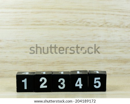 number 1, 2, 3, 4, 5 arranged in line isolated on wooden background