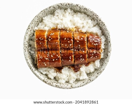 Cooked steamed rice topped with grilled eel sprinkle with white sesame seeds or Unagi don Japanese food isolated on white background.
