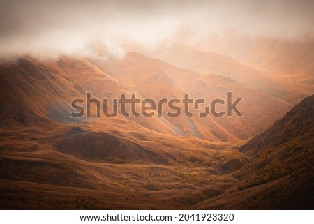 Yellow autumn mountains in misty morning. Gil-Su valley in North Caucasus, Russia. Beautiful autumn landscape
