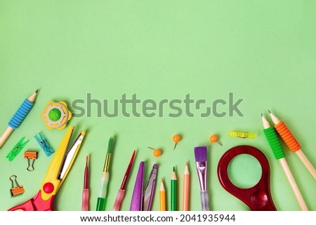 Different school supplies on the green background.Back to school concept,top view.