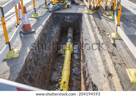 Underground pipe being fixed in trench Royalty-Free Stock Photo #204194593