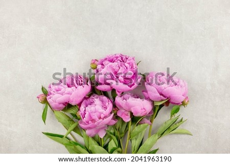 Bouquet of pink peonies flowers on light gray concrete background. Valentine's, womens, mothers day, easter, birthday or wedding, spring holiday flat lay. Top view. Copy space.