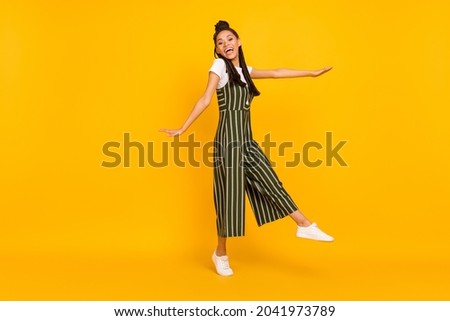 Full body photo of happy dark skin young woman good mood enjoy free time isolated on yellow color background
