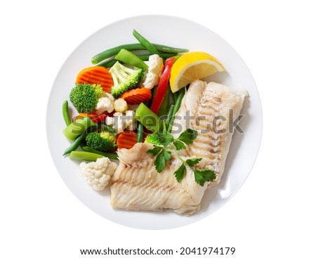 Plate of fried cod fish fillet with vegetables isolated on white background, top view