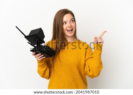 Teenager girl holding a drone remote control over isolated white background intending to realizes the solution while lifting a finger up