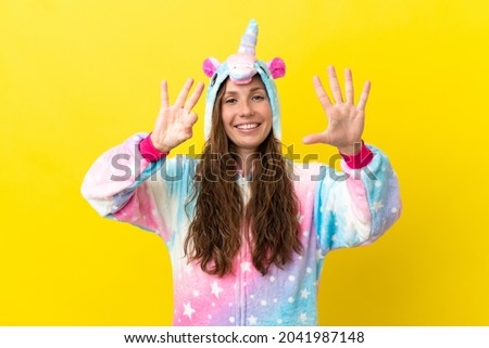 Girl with unicorn pajamas over isolated background counting eight with fingers