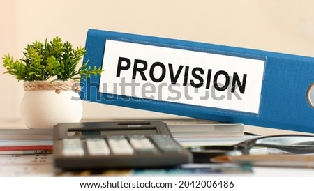 provision - blue binder on desk in the office with calculator, pen and green potted plant. Can be used for business, financial, education, audit and tax concept. Selective focus. Royalty-Free Stock Photo #2042006486