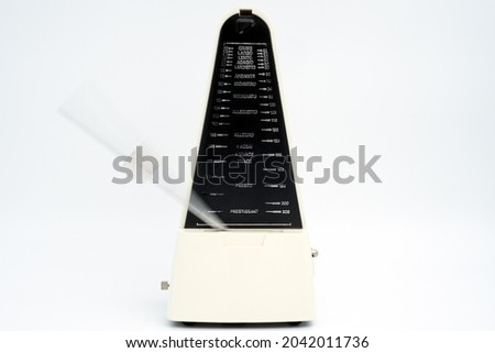 Vintage white old metronome used in music studies.