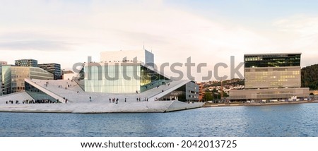 Oslo, Norway. Scenic Night Evening View Of Illuminated Norwegian National Opera And Ballet House Among Contemporary High-Rise Buildings. Panorama, Panoramic View. Royalty-Free Stock Photo #2042013725