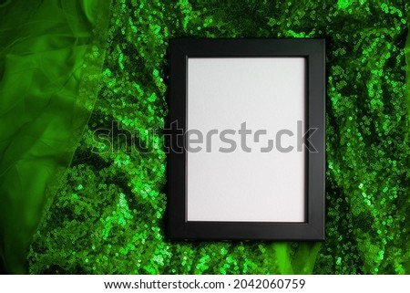 Black frame on green sparkling fabric background