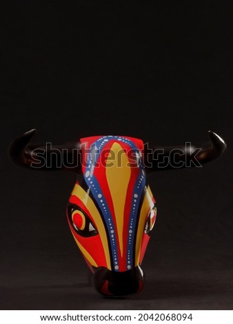 Bull mask of the Barranquilla Carnival in black background 