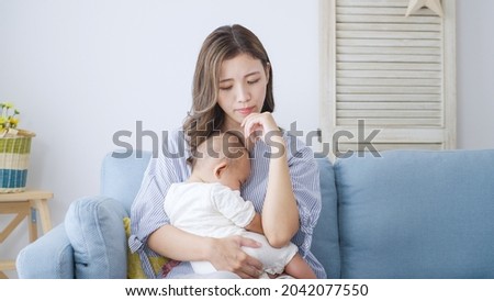 Thinking Asian mom and baby at home