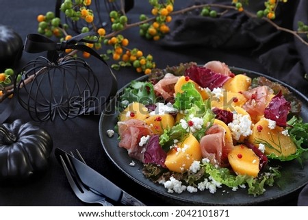 Persimmon and prosciutto ham autumn appetizer salad for Halloween or Thanksgiving.