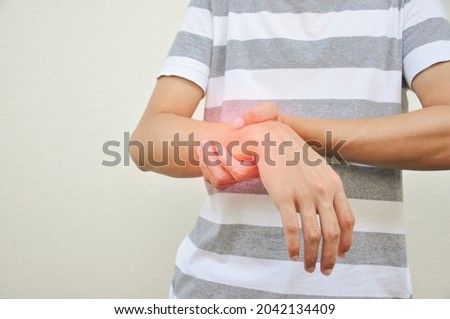 man support a hand part that experiencing pain 