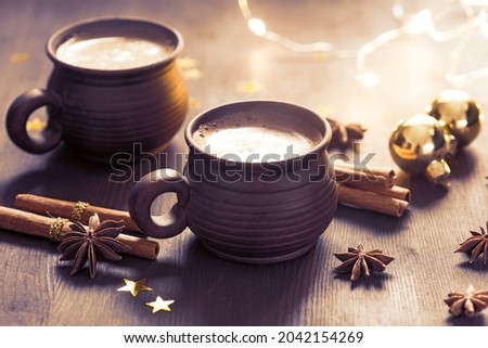 Two brown clay cups of black coffee,  Christmas decoration, spices on  the wooden table. Selective focus. Toned image