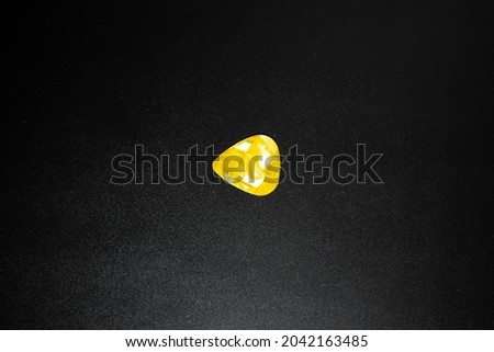Yellow abstract texture of cheap pick guitar on black background with lighting