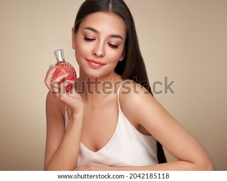 Young beautiful woman with a bottle of perfume. Model with healthy skin, close up portrait. Cosmetology, beauty and spa Royalty-Free Stock Photo #2042185118