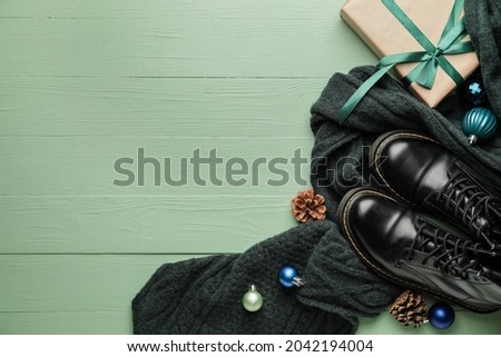 Christmas composition with stylish clothes and accessories on color wooden background