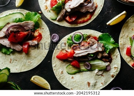  Corn tortillas stuffed with chicken and vegetables on a wooden table. Cooking tacos.