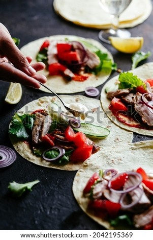  Corn tortillas stuffed with chicken and vegetables on a wooden table. Cooking tacos.