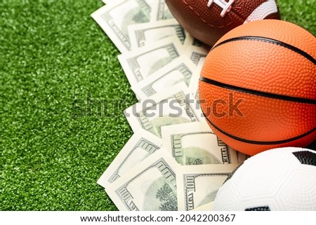 Money and balls on color background. Concept of sports bet Royalty-Free Stock Photo #2042200367