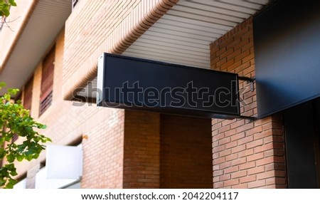 Black commercial signboard blank space for mockup for branding design on a store wall in the street