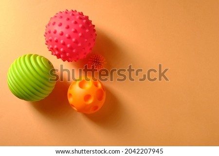 Baby massage balls on an orange background, place for an inscription, top view