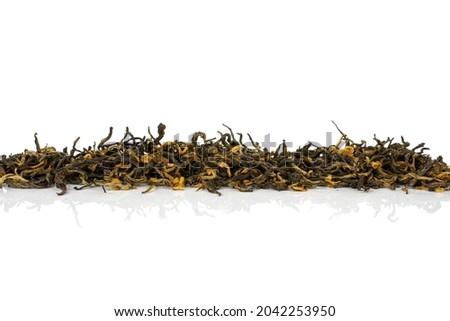 Dry black tea leaves in row isolated on white background