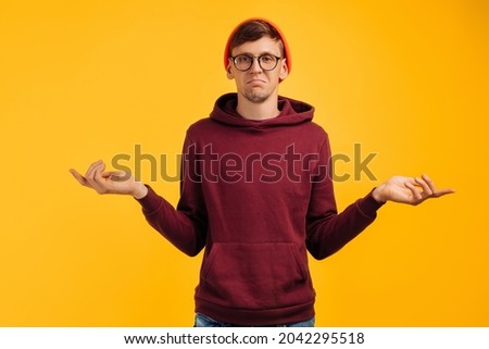 man spreads his arms in different directions, shrugs, unsure of himself
